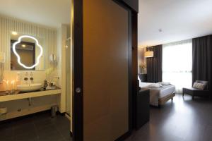 热那亚贝斯特韦斯特酒店CHC机场店的一间带水槽的浴室和一间带床的房间