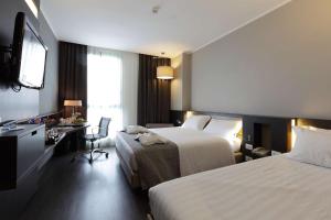 热那亚贝斯特韦斯特酒店CHC机场店的酒店客房配有两张床和一张书桌