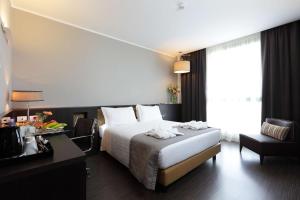 热那亚贝斯特韦斯特酒店CHC机场店的配有一张床、一张书桌和一扇窗户的酒店客房