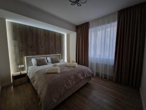 基希讷乌Dendrarium Park Apartment Deluxe的一间卧室配有一张大床和两条毛巾
