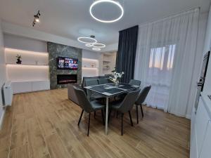 基希讷乌Dendrarium Park Apartment Deluxe的一间带桌椅和壁炉的用餐室