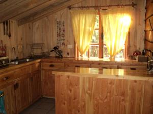 柯纳里佩Cabaña Rustica Patagonia Chilena的厨房配有木制橱柜和带窗帘的窗户。