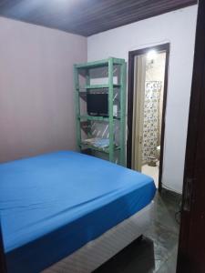 里约热内卢Mangue House lll的一间卧室设有蓝色的床和绿色架子