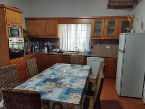 CalhetaCasa da Eira的厨房配有桌椅和白色冰箱。
