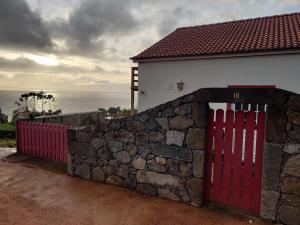 CalhetaCasa da Eira的房屋旁石墙中的红色门