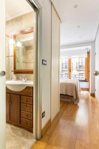 圣塞瓦斯蒂安Luxury Old TownGeneral Jauregi的一间带水槽和镜子的浴室以及一张床