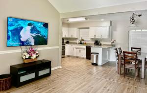 杰克逊维尔Beautiful Beach house with heated pool的厨房以及带壁挂式大电视的用餐室。