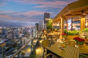 岘港钻石海酒店的一个带桌椅的阳台,享有城市天际线