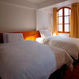 瓦拉斯Akilpo Home的带窗户的客房内的2张白色床