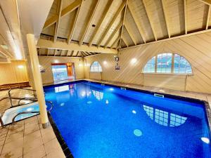 格伦科Loch Linnhe Waterfront Lodges with Hot Tubs的一座大型游泳池,位于一座带大型游泳池的建筑中
