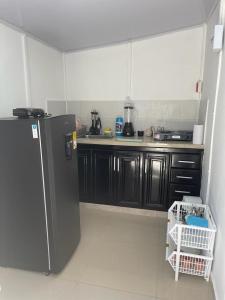 里奥阿查Apartamento Vacacional Riohacha的厨房配有黑色橱柜和冰箱。