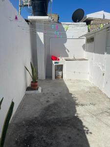 里奥阿查Apartamento Vacacional Riohacha的庭院设有白色的墙壁、桌子和植物