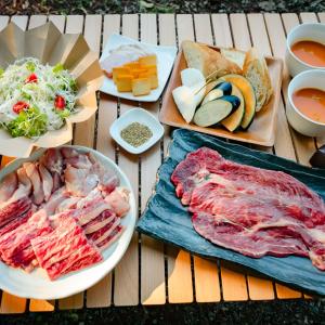 丰冈市煙神キャンプヴィレッジ的一张桌子,上面有不同种类的肉和食物