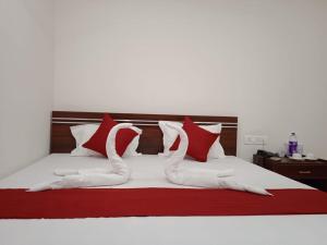 古瓦哈提HOTEL HAREN GRAND的一张带红色和白色枕头的床