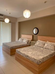 纳苏格布Luxurious Family Room Pico de Loro的一间卧室设有两张床、镜子和吊灯