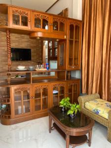 Ban Bang BoKp. เพลส หลวงแพ่ง (Kp. Place Luang Phaeng)的客厅配有木制橱柜和咖啡桌。