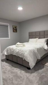 埃德蒙顿3 Bedroom Single Family Home的一间卧室配有一张带白色床单的大床
