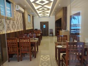 布莱尔港HOTEL IDHAYA的用餐室配有木桌和椅子