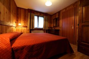 布吕松Valley Vacanze的一间卧室配有一张带橙色棉被的床