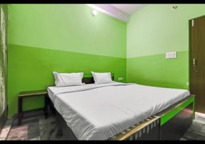 阿格拉Dev Guest House By WB Inn的绿色的客房设有一张大床