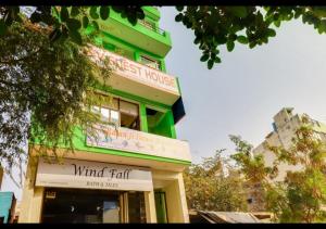 阿格拉Dev Guest House By WB Inn的绿色建筑上带有风降标志