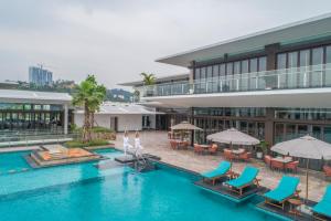 下龙湾Oakwood Ha Long的享有酒店游泳池的顶部景色,设有椅子和遮阳伞