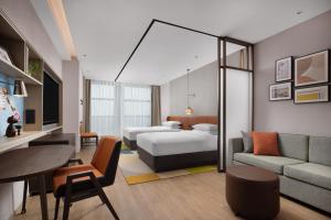贵阳贵阳航空港希尔顿惠庭酒店的酒店客房,配有床和沙发