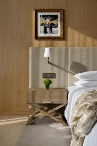 迪拜The Dubai EDITION的一间卧室配有一张床和一张桌子,上面有植物