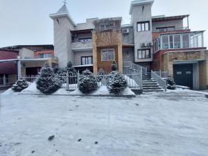 塞米伊TURAN SEMEY GRAND HOTEL的前面的地面上积雪的建筑