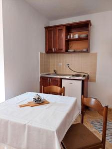 多布拉沃达Apartments Normannia的厨房配有一张桌子,上面有白色的桌布