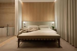迪拜The Dubai EDITION的一间卧室配有一张带白色床单的大床