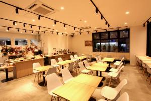 札幌Sotetsu Fresa Inn Sapporo-Susukino的配有木桌和白色椅子的餐厅