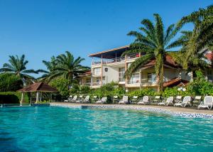布琼布拉Hotel Safari Gate的一个带游泳池、椅子和棕榈树的度假村