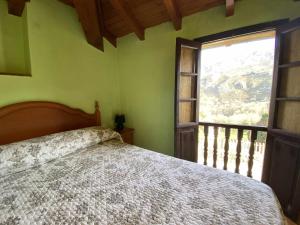 阿里翁达斯Casa El Marizal 1 Arriondas的一间卧室设有一张床和一个大窗户