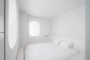 东京BnA WALL的白色的客房设有一张床和两个窗户。