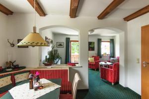 雷特温克尔夕阳公寓的厨房以及带桌子和红色椅子的客厅。