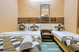 孟买Terminus Hotel Bandra的一间卧室配有两张床和镜子