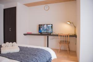 大阪QUEENS PARK的一间卧室配有一张床和一张书桌及电视