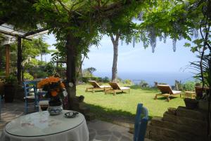 马尔恰纳Hotel Sant'Andrea的庭院设有桌椅,享有美景。