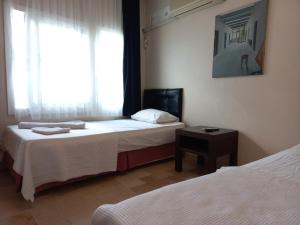 切什梅Blue otel çeşme的酒店客房设有两张床和窗户。