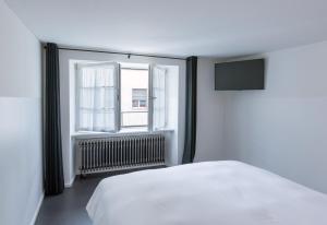 苏黎世马克加赛酒店的卧室配有白色的床和窗户。