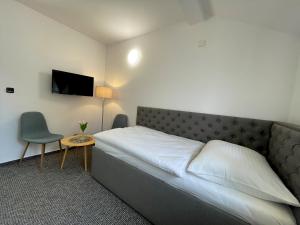 UničovHotel COLCHI的一间卧室配有一张床、一张桌子和一台电视。