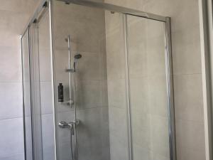 森格莱阿Dghajsa GUEST HOUSE的浴室里设有玻璃门淋浴