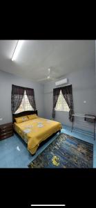 丹那美拉Casa Harmony的一间卧室配有一张带黄毯的床和两个窗户
