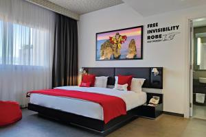 贝鲁特思玛维尔酒店的一间卧室配有一张带红色枕头的大床
