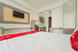 TegalgedeRedLiving Apartemen Riverview Residence - TOHA Room Tower Mahakam的卧室配有白色的床和平面电视。