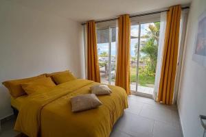 勒唐蓬Villa, Lossy的一间卧室设有黄色的床和窗户。