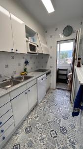 埃斯塔蒂特Estartit Delta 4C的厨房配有白色橱柜和瓷砖地板。