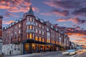 科克The Metropole Hotel Cork的一条城市街道上一座大建筑,享有日落美景