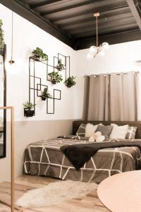 安蒂波洛Gorgeous Studio Suite w/ King size bed的卧室配有一张挂在墙上的植物床